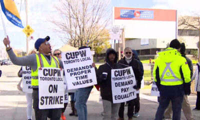 Canada Post workers are seen on a picket line