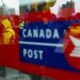 The strike by more than 55,000 Canada Post workers entered its 19th day as the Black Friday and Cyber Monday shopping weekend came to a close. Canada Post employees and supporters rally as they are reflected in a window at Canada Post headquarters in Ottawa, Thursday, Nov. 28, 2024.