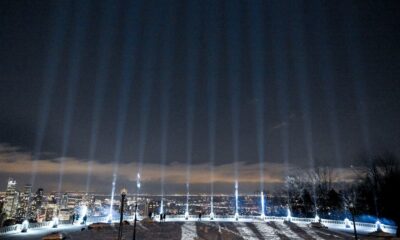 Fourteen beams of light are projected into the sky during a vigil to honour the victims of the 1989 Polytechnique massacre in Montreal on Dec. 6, 2023