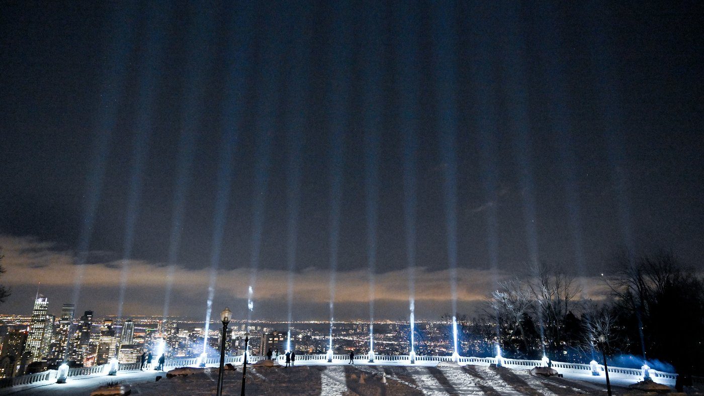 Fourteen beams of light are projected into the sky during a vigil to honour the victims of the 1989 Polytechnique massacre in Montreal on Dec. 6, 2023