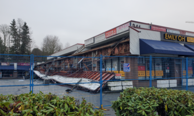 A Coquitlam strip mall remains fenced off on Jan. 5, 2025, a week after a destructive fire.