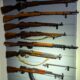 Seven firearms hung on a wall