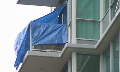 Tarps can be seen covering a balcony on East Esplanade Avenue in North Vancouver after a fatal incident on Aug. 20, 2024.
