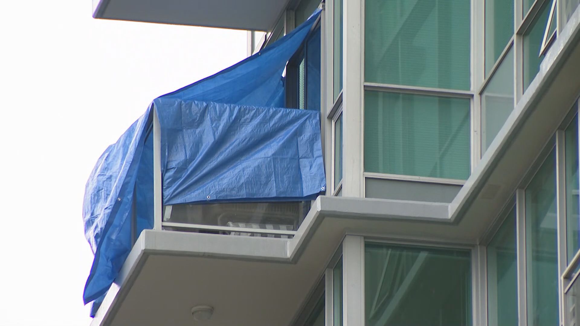 Tarps can be seen covering a balcony on East Esplanade Avenue in North Vancouver after a fatal incident on Aug. 20, 2024.