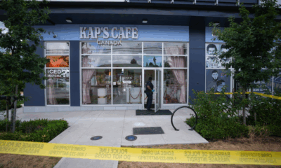 An RCMP officer enters a café that was shot at, in Surrey, B.C., on Thursday, Aug. 7, 2025. Police are investigating after shots were fired for the second time within a month at Kap