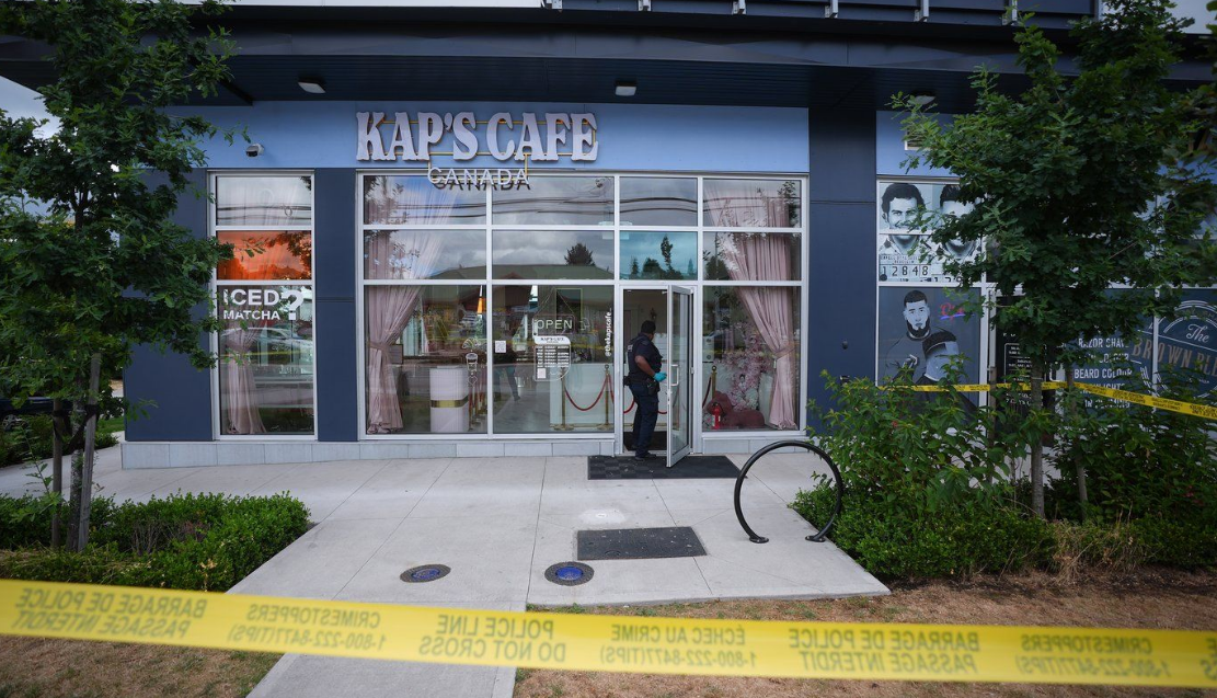 An RCMP officer enters a café that was shot at, in Surrey, B.C., on Thursday, Aug. 7, 2025. Police are investigating after shots were fired for the second time within a month at Kap